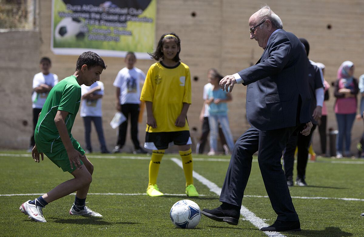 El presidente de la Fifa, Sepp Blatter, patea una pelota durante la inauguración de un estadio de fútbol en el pueblo de Dura Al-Qari', cerca de Ramala, Palestina. (AP/Majdi Mohammed)