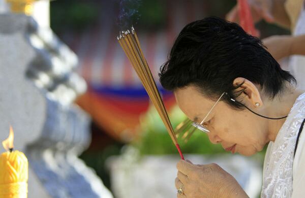 Una mujer ora con incienso prendido en frente del monumento para honrar a las víctimas del “Campo de la muerte”, en Phnom Penh, Camboya. (AP)
