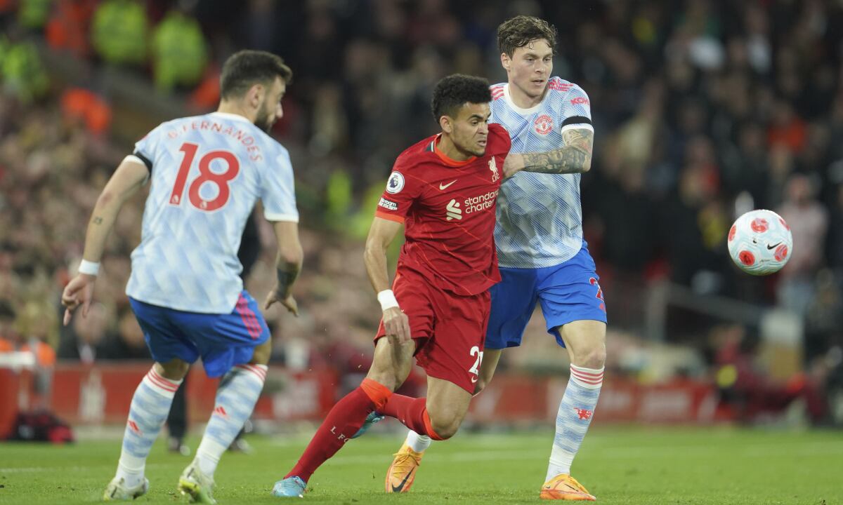 Liverpool's Luis Diaz, center, fights for the ball with Manchester United's Victor Lindelof during the English Premier League soccer match between Liverpool and Manchester United at Anfield stadium in Liverpool, England, Tuesday, April 19, 2022. (AP/Jon Super)