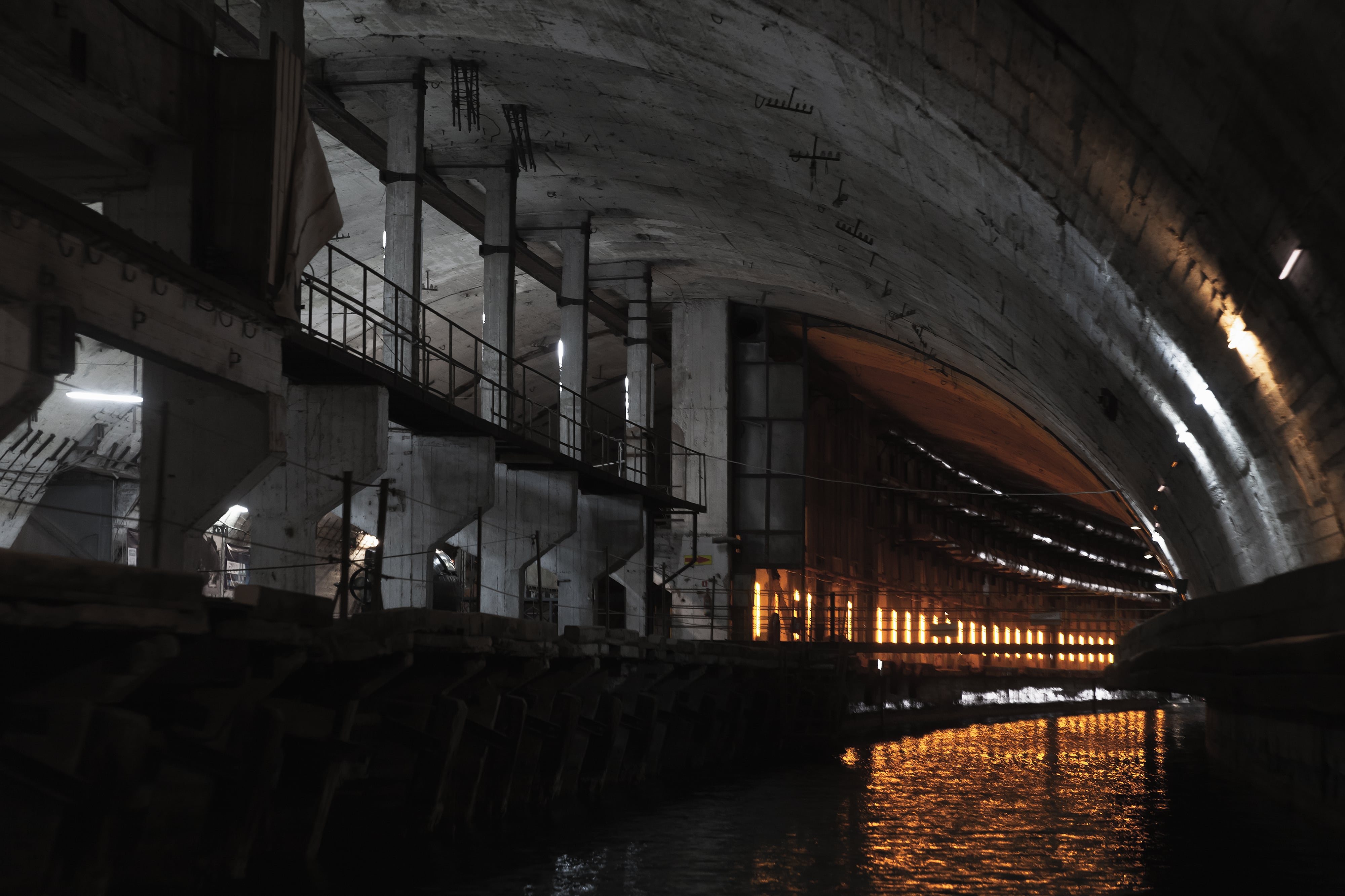 Perspectiva de un túnel industrial de hormigón iluminado. Imagen de referencia