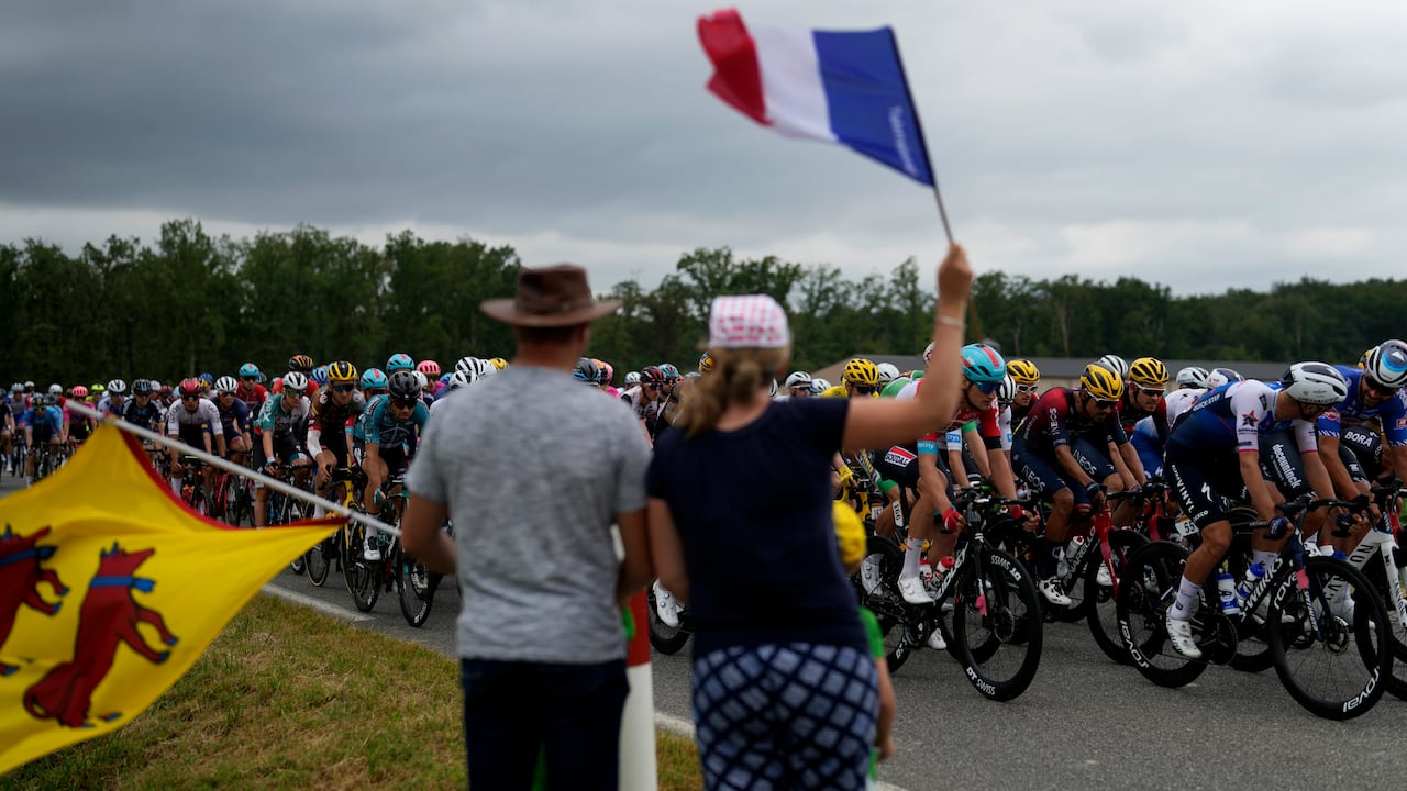Los espectadores saludan el paso del pelotón del Tour de Francia durante la 19na etapa, el viernes 22 de julio de 2022.
