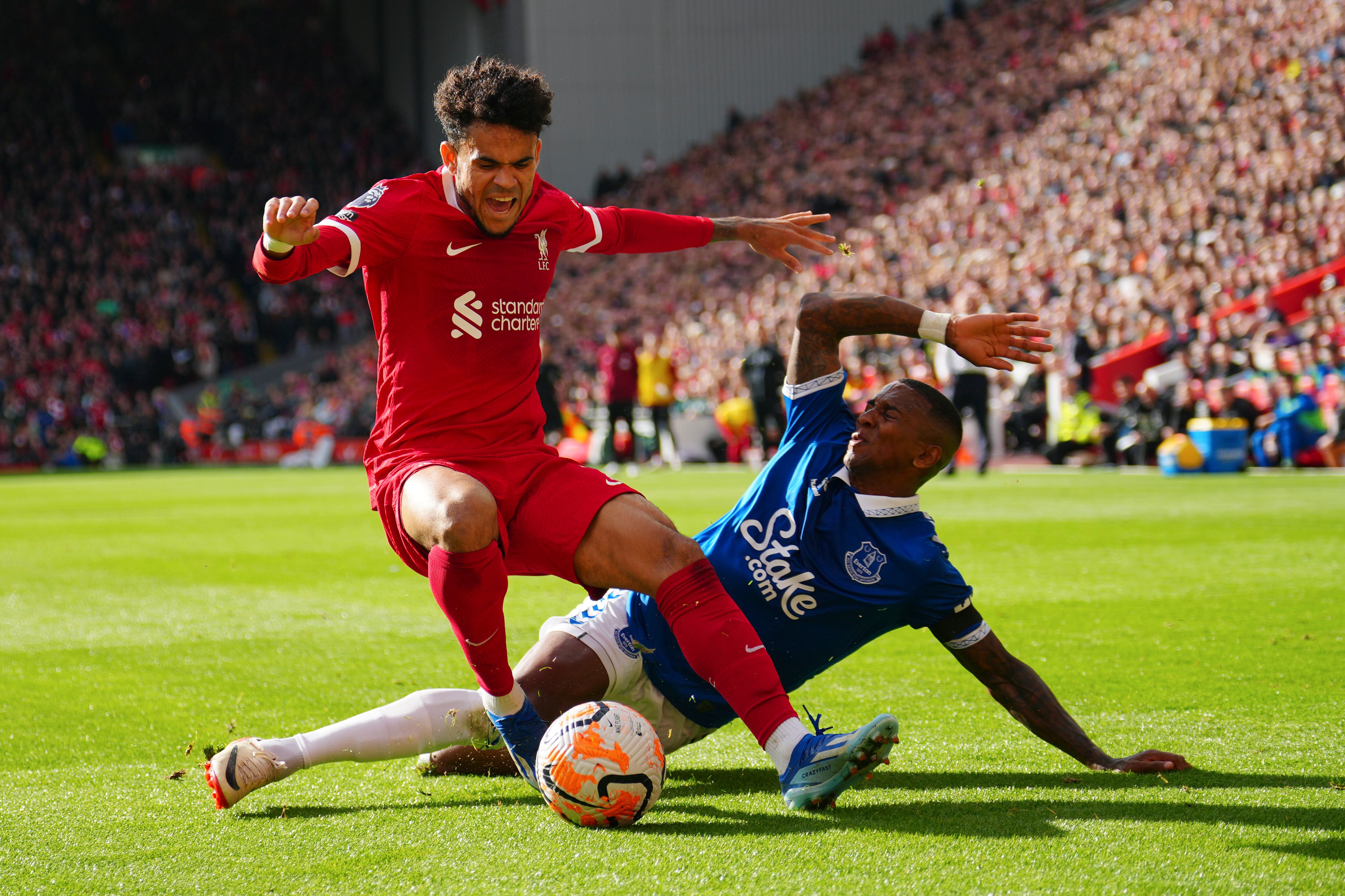 Liverpool's Luis Diaz, left, challenges for the ball with Everton's Ashley Young during the English Premier League soccer match between Liverpool and Everton, at Anfield in Liverpool, England, Saturday, Oct. 21, 2023. (AP Photo/Jon Super)