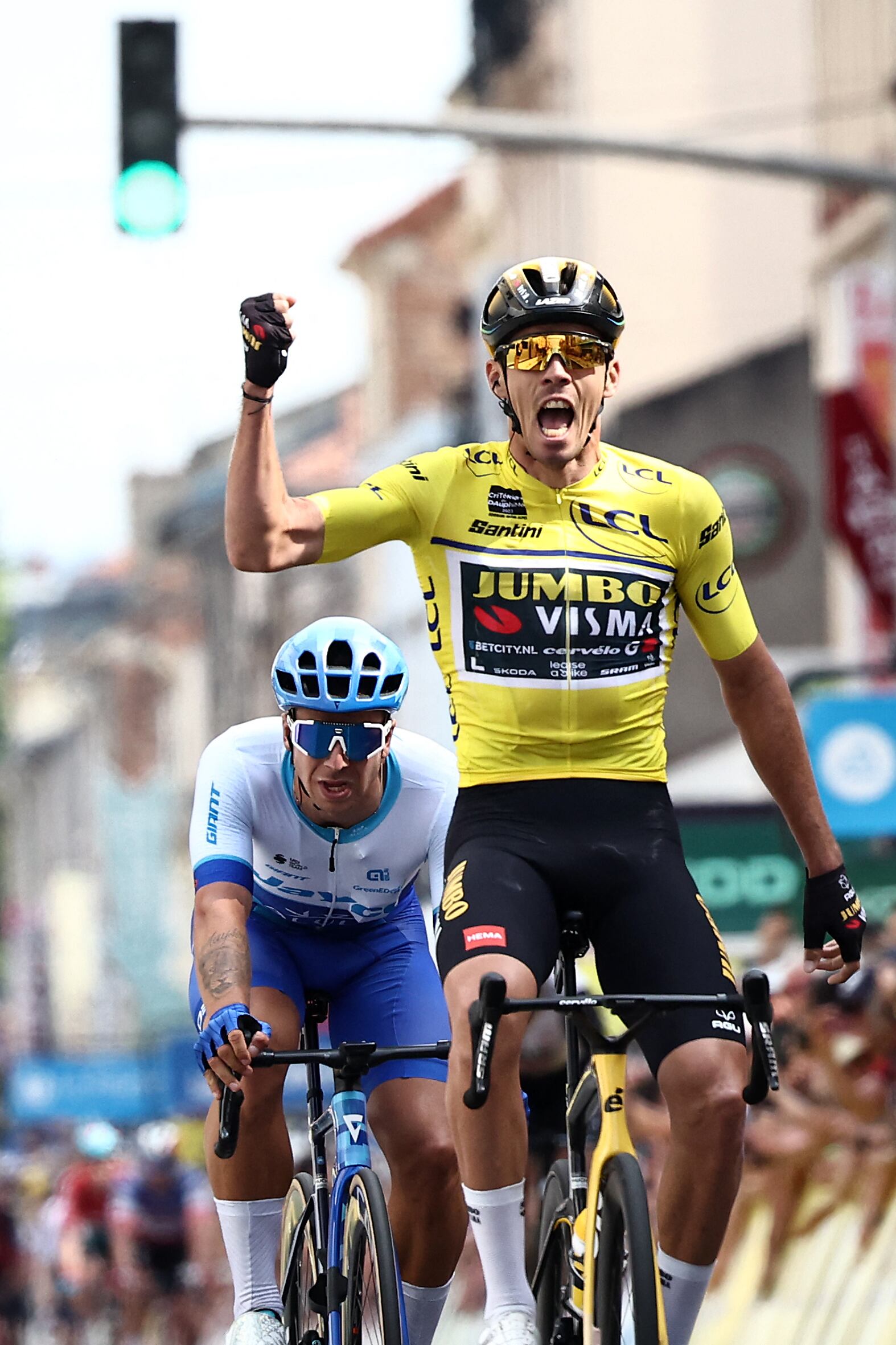 Yellow jersey of Overall Leader Jumbo-Visma's French rider Christophe Laporte (R) celebrates next to Team Jayco AlUla's Dutch Dylan Groenewegen, as he crosses the finish line to win the third stage of the 75th edition of the Criterium du Dauphine cycling race, 194,5 kms between Monistrol-Sur-Loire and Le Coteau, central-eastern France, on June 6, 2023. (Photo by Anne-Christine POUJOULAT / AFP)