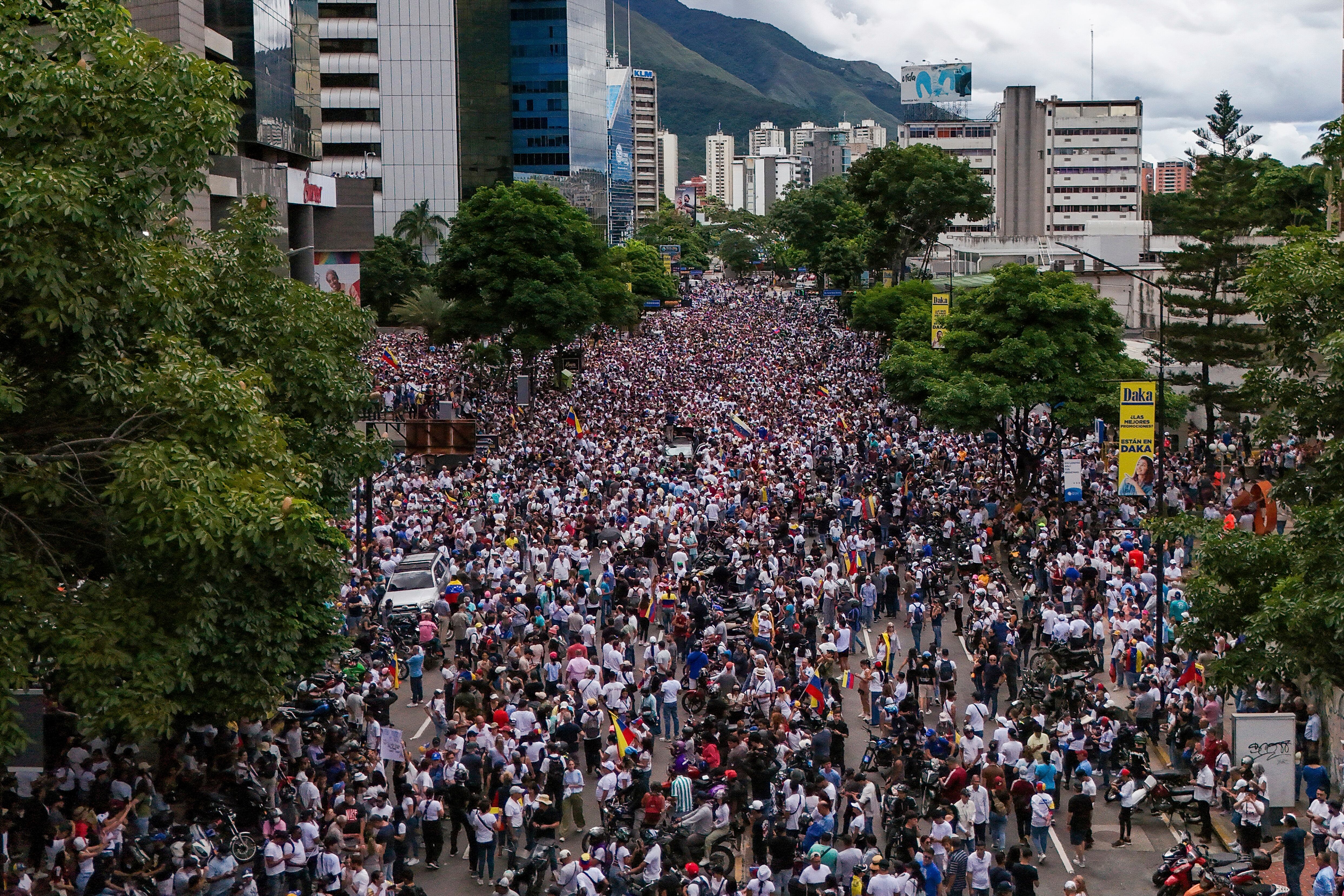 La líder de la oposición María Corina Machado y el candidato presidencial Edmundo González saludan a sus partidarios durante una protesta contra los resultados oficiales de las elecciones que declaran ganador al presidente Nicolás Maduro en Caracas.