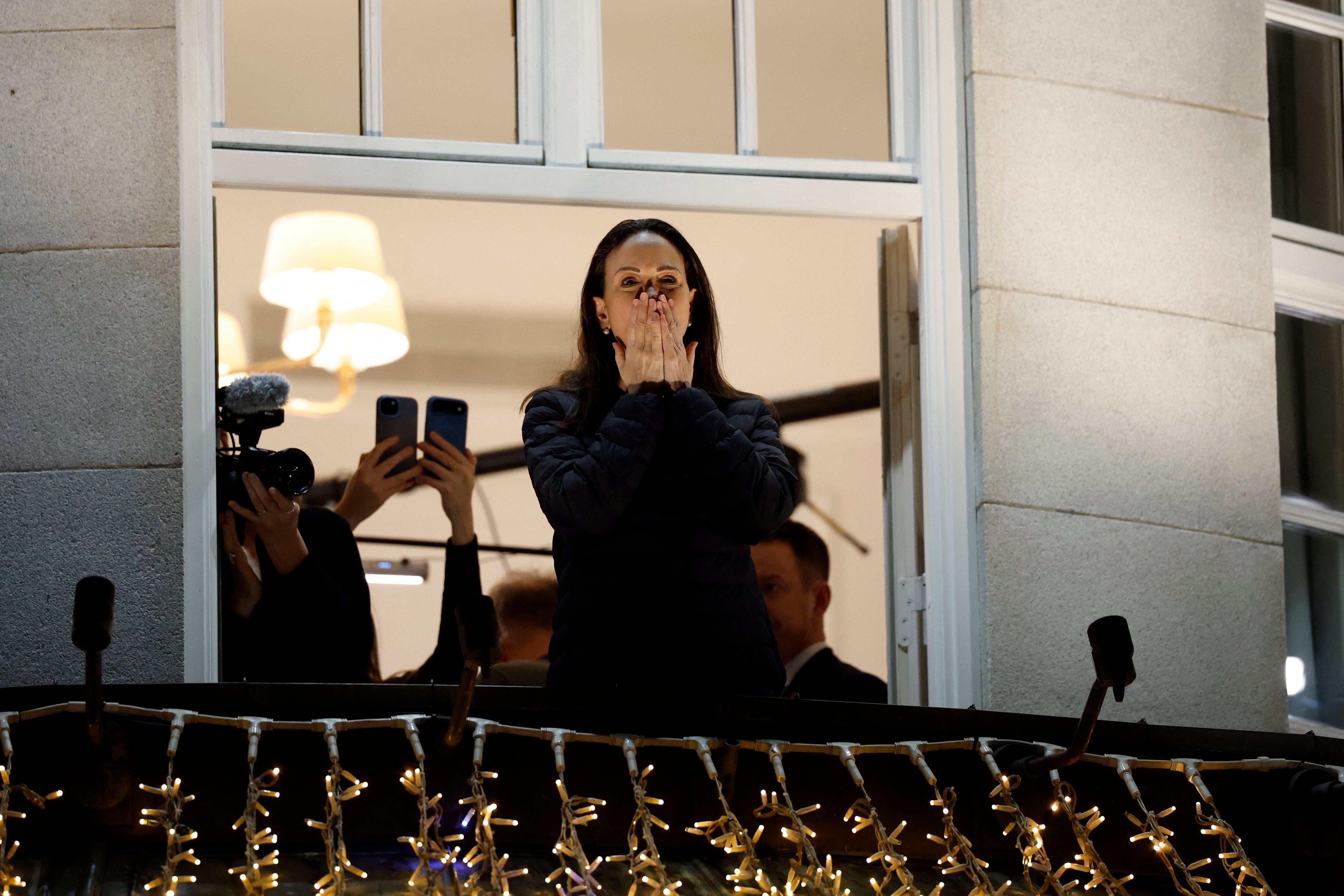 Premio nobel de la Paz, María Corina Machado, saluda desde un balcón del Grand Hotel de Oslo, Noruega.
