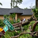 Oscar Garcia (R) with his family stands outside his house after getting hit by a reported tornado in Fort Myers, Florida, on October 9, 2024, as Hurricane Milton approaches. Florida residents fled or just hunkered down in the final hours October 9 before Milton pummels the state, as government emergency relief efforts were dragged to the center of the US election. (Photo by CHANDAN KHANNA / AFP)