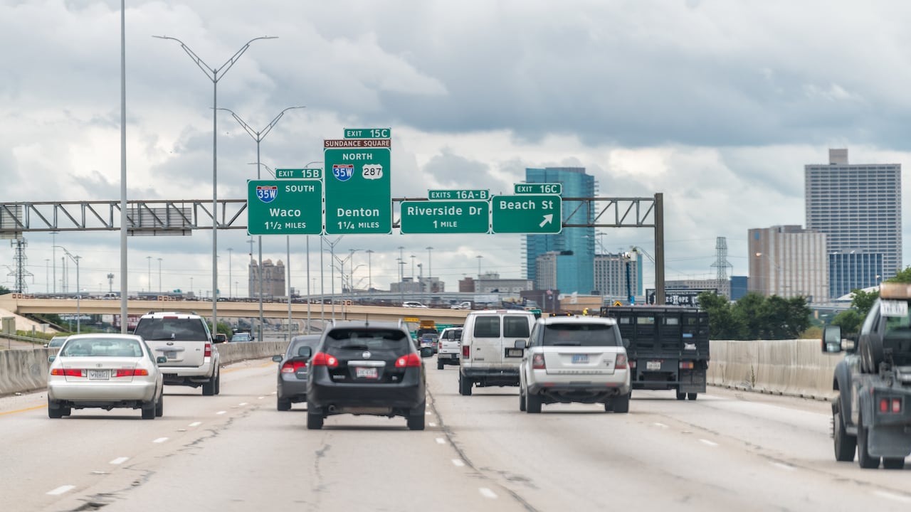 Fort Worth, USA - June 7, 2019: Interstate highway road in city in Texas with many cars on commute and sign for exit