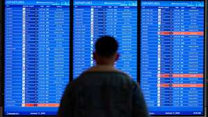 A traveler looks at a flight board with delays and cancellations at Ronald Reagan Washington National Airport in Arlington, Va., Wednesday, Jan. 11, 2023. Flights are being delayed at multiple locations across the United States after a computer outage at the Federal Aviation Administration. (AP Photo/Patrick Semansky)