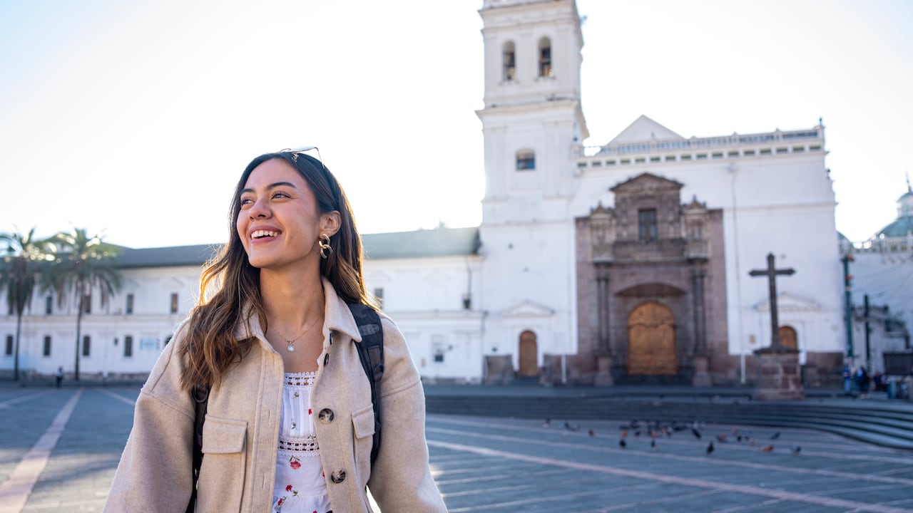 Joven latina haciendo turismo en la iglesia y la plaza de Santo Domingo, Quito, Ecuador.