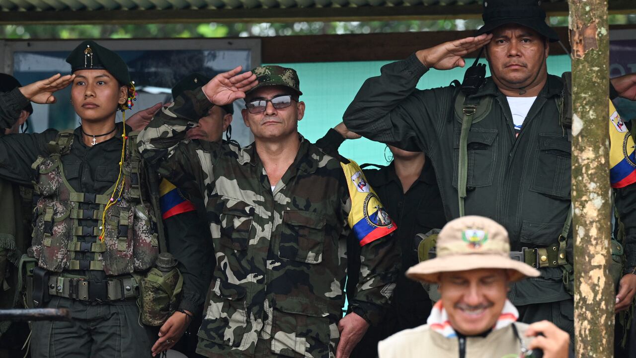 FARC-EP dissidence top commander, aka Ivan Mordisco (C), gives a military salute next to commander Calarca (R) during a meeting with local communities in San Vicente del Caguan, Caqueta department, Colombia, on April 16, 2023. An armed dissident group of Colombia's disbanded FARC guerrillas said Sunday it was "ready" to start peace talks with the government from May 16. "We are announcing to the world that our delegates to the dialogue table with the Colombian government... are ready for May 16," the EMC dissident grouping, which rejected a 2016 peace deal that disarmed the FARC, said through a spokesperson. (Photo by JOAQUIN SARMIENTO / AFP)