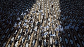 Personas que llevan banderas israelíes caminan a través de una instalación que marca el tercer aniversario del 7 de octubre de 2023, cuando Hamás atacó a Israel. Playas de Tel Aviv, Israel, el miércoles 7 de octubre de 2026.