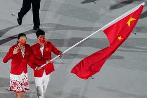 Zhu Ting y Zhao Shuai, de China, llevan la bandera de su país durante la ceremonia de apertura en el Estadio Olímpico de los Juegos Olímpicos de Verano de 2020, el viernes 23 de julio de 2021 en Tokio. Foto: AP / Morry Gash.