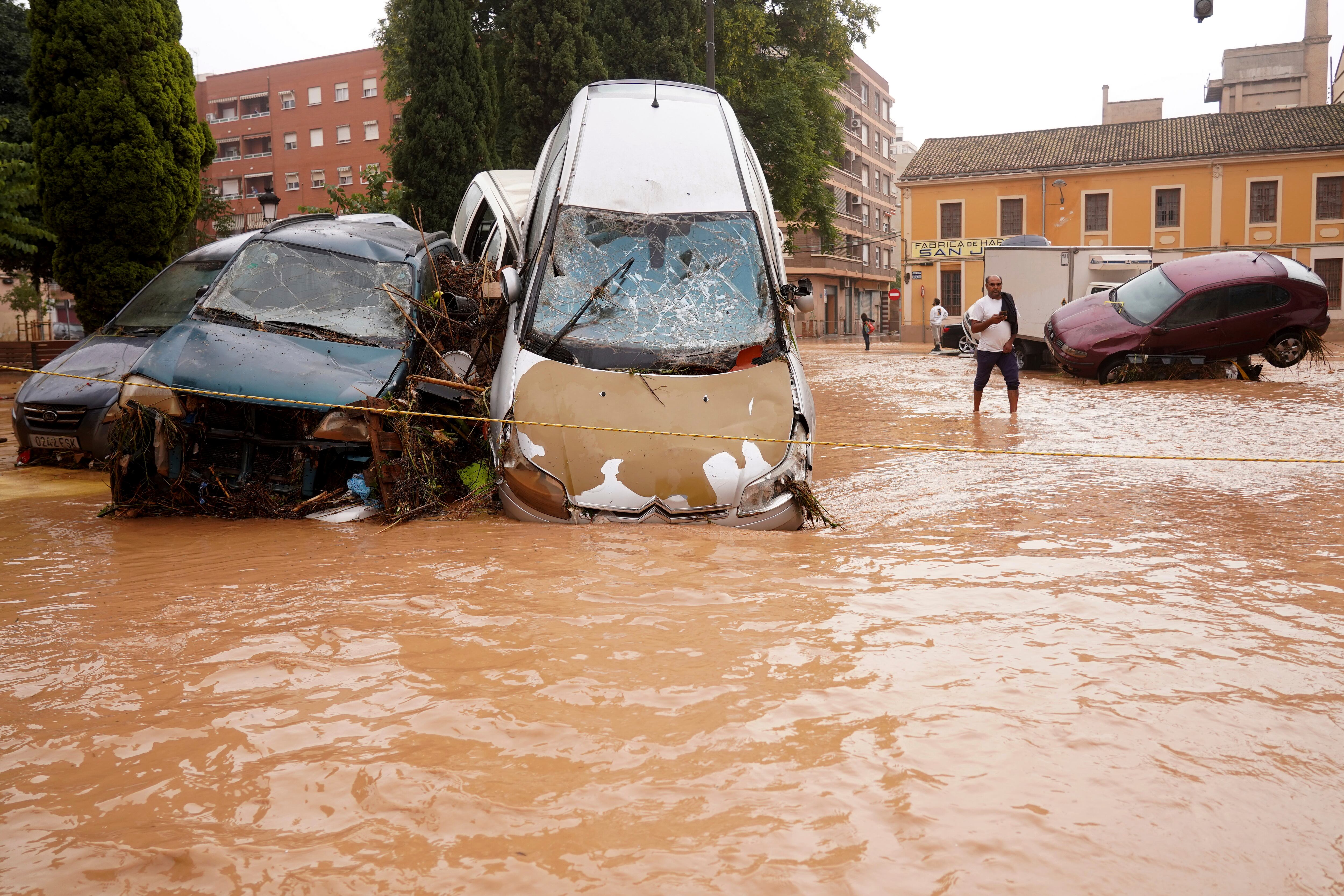 A man walks through flooded streets in Valencia, Spain, Wednesday, Oct. 30, 2024. (AP Photo/Alberto Saiz)