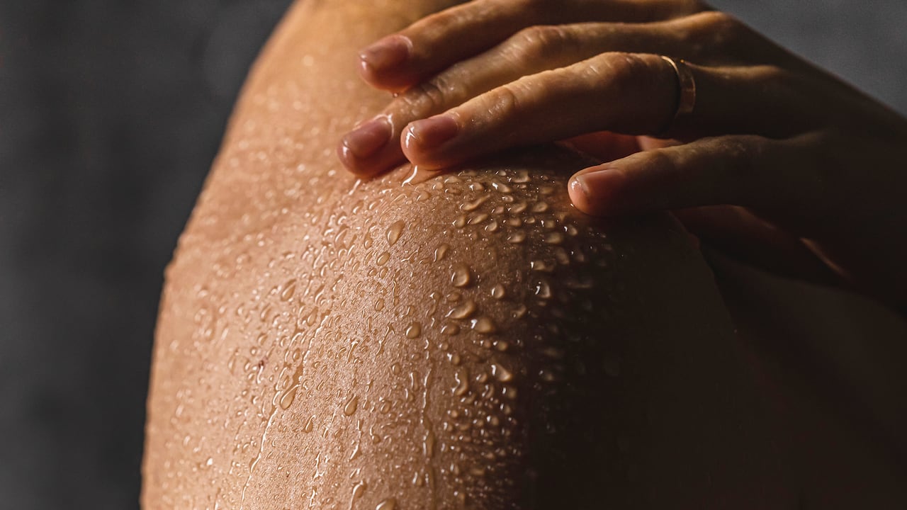 Foto de referencia de gotas de agua sobre la piel de una mujer