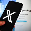 POLAND - 2023/07/28: In this photo illustration a New Twiiter logo (X) is displayed on a smartphone with Twitter website in the background. (Photo Illustration by Omar Marques/SOPA Images/LightRocket via Getty Images)