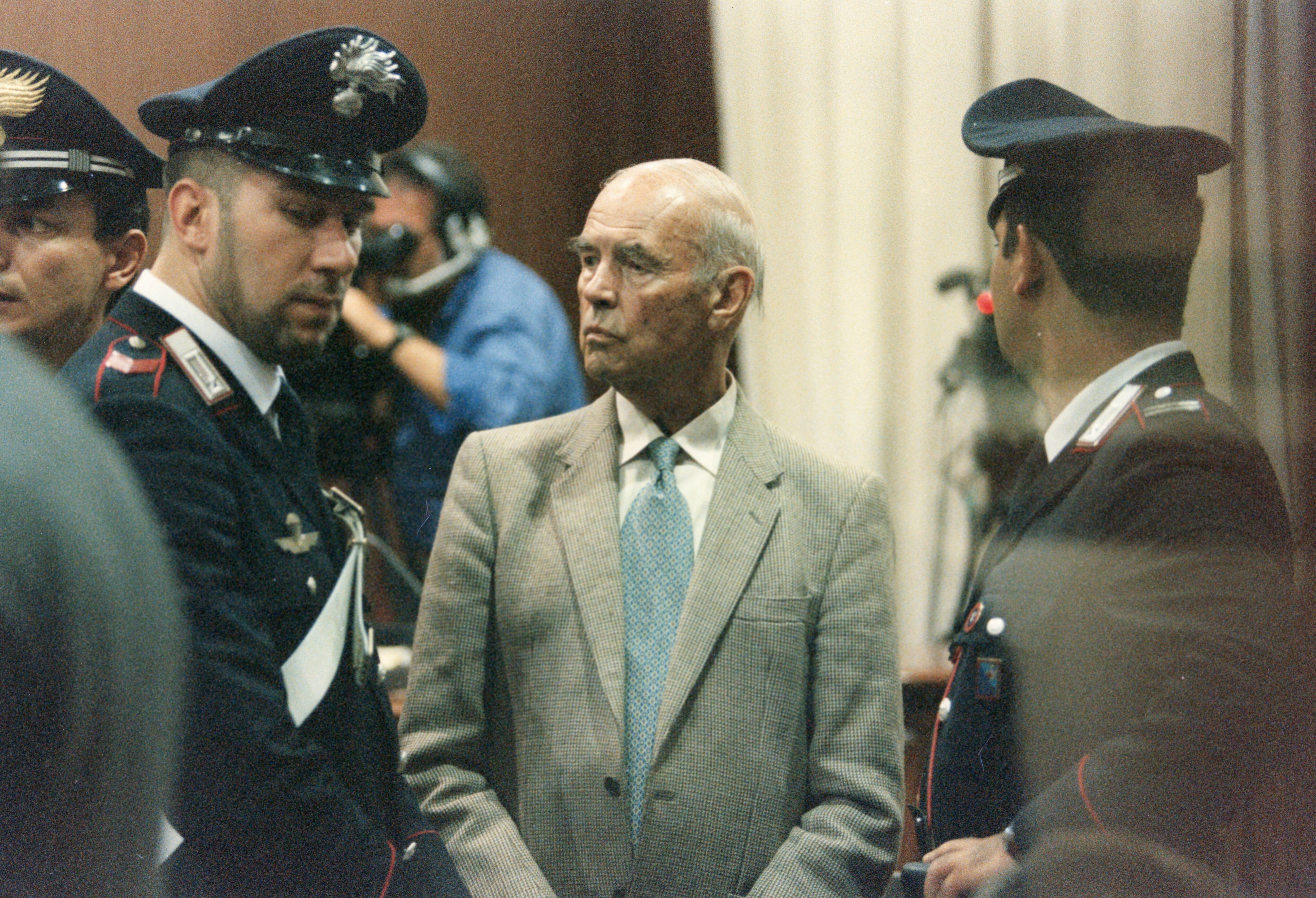 L'ancien capitaine SS Erich Priebke entouré de policiers lors de son jugement pour crimes de guerre à Rome en mai 1997, Italie. (Photo by Livio ANTICOLI/Gamma-Rapho via Getty Images)
