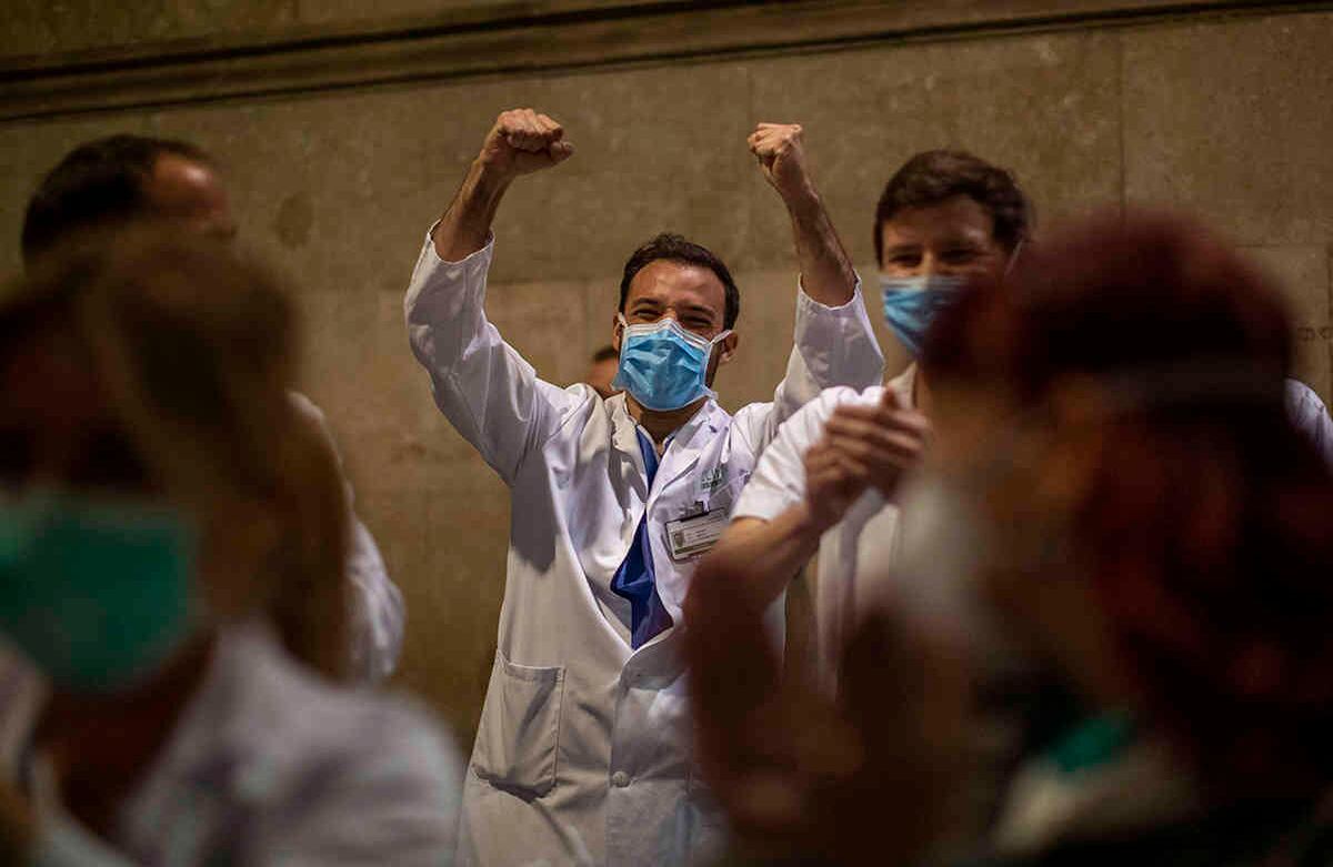 Médicos en Barcelona reaccionan a los aplausos de las personas, que desde sus casas intentan mostrarles su agradecimiento por el esfuerzo que están haciendo frente a la pandemia. En España, la situación cada vez está más crítica. Recientemente se conoció que además del colapso del sistema de salud, los adultos mayores también están viviendo en malas condiciones en los hogares, a causa del virus. Foto: Emilio Morenatti/ AP. 