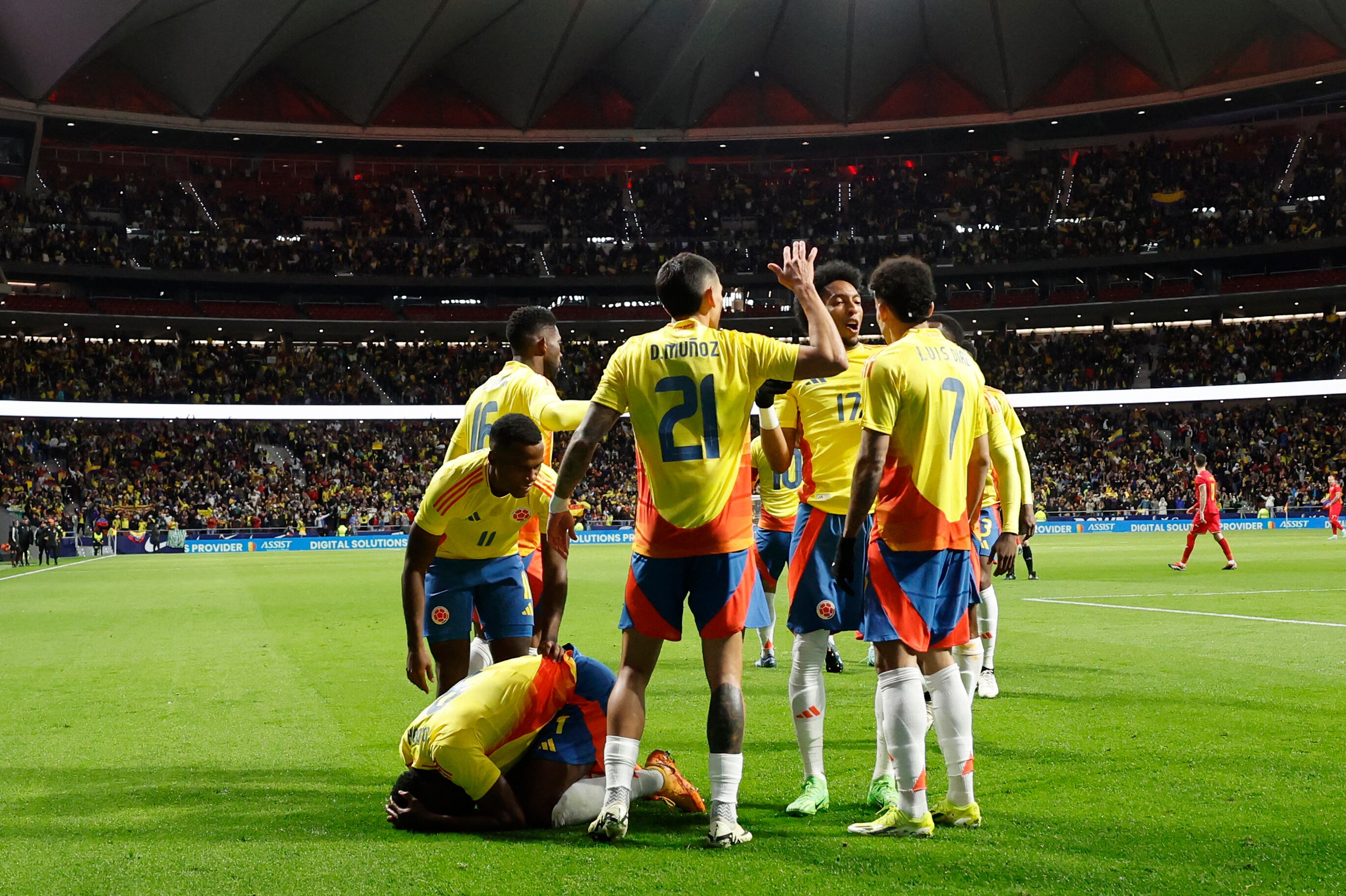 Colombia's forward #09 Jhon Cordoba (down) celebrates with teammates after scoring his team's first goal during the international friendly football match between Romania and Colombia at the Metropolitano stadium in Madrid on March 26, 2024. (Photo by OSCAR DEL POZO / AFP)