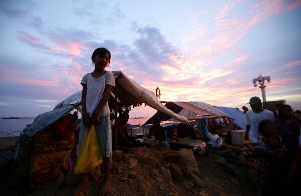 Una lugareña que huye de la lucha entre fuerzas gubernamentales y rebeldes islamistas carga una bolsa con artículos dada por el gobierno. (AP)
