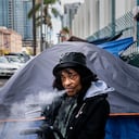 Una mujer sin hogar que acaba de llegar del medio oeste fuma fentanilo fuera de su tienda de campaña en San Diego, California, el viernes 24 de marzo de 2023.