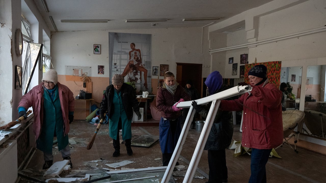 Mujeres limpian escombros en una clase de baile escolar dañada tras un ataque aéreo en Kiev el 3 de febrero de 2026.