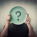 Anonymous man hiding his identity, covering face using an empty dish plate with question mark. Global crisis, food supply problem. Conceptual message, starvation and famine issue. Hunger diet concept