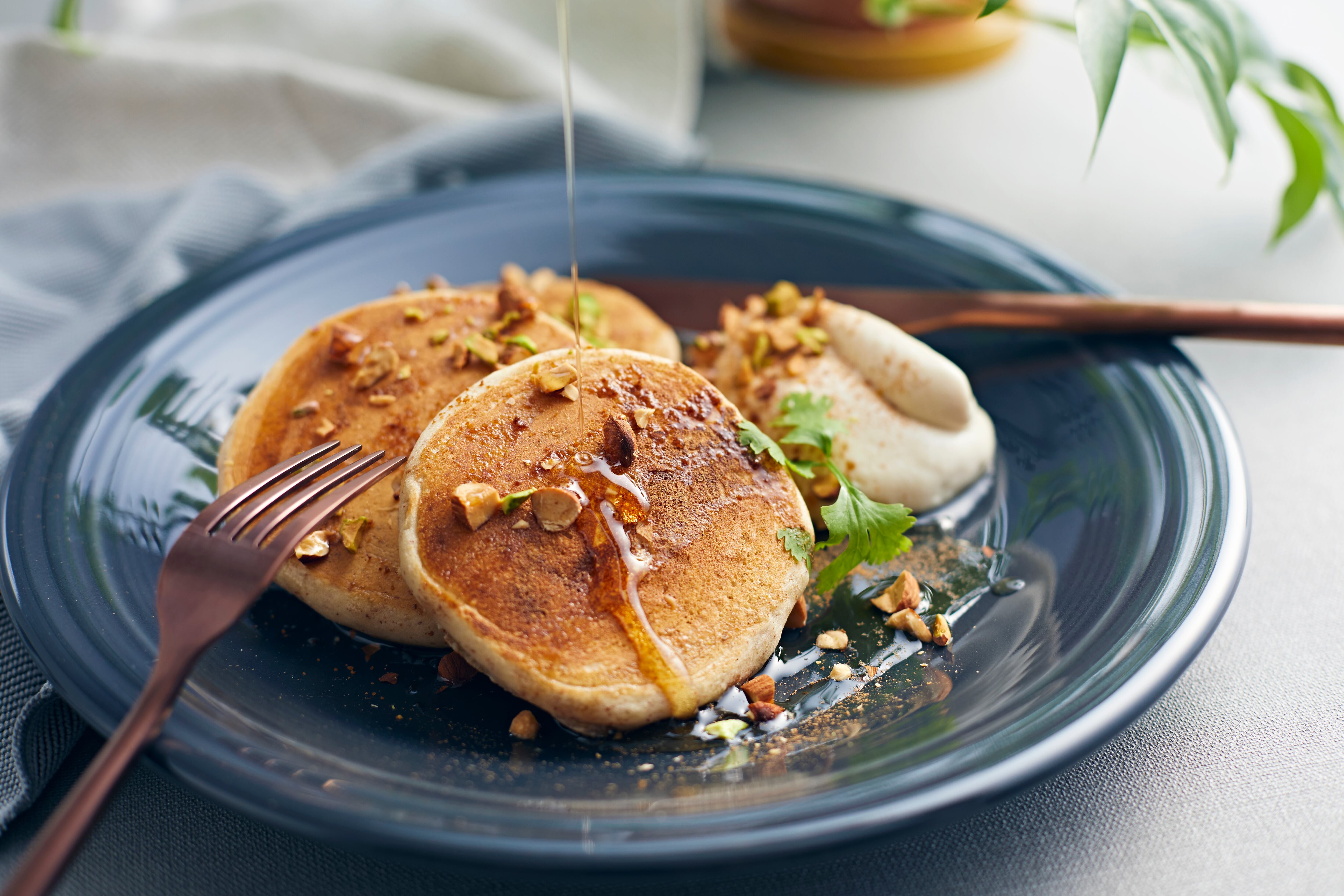 Serve the pancakes on a round plate with maple syrup.