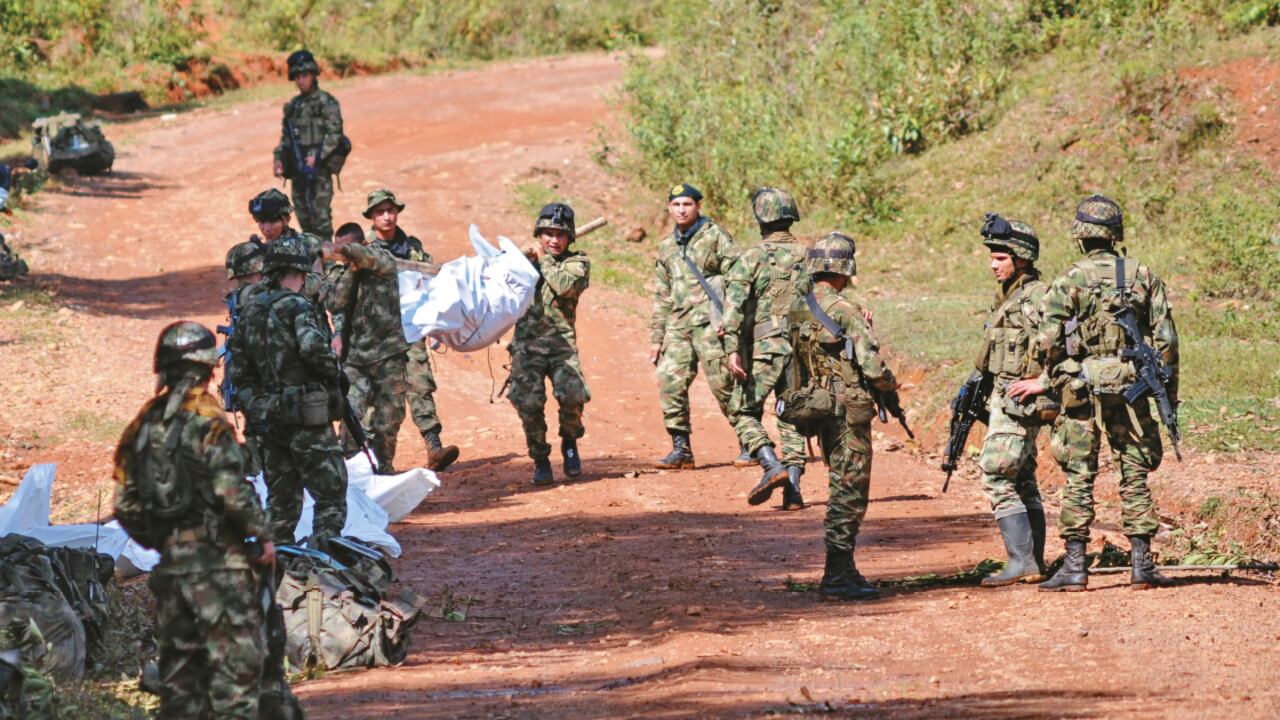 SIN EXPLICACIONES - El ataque sorpresivo en Cauca dejó en entredicho el cese del fuego declarado por las Farc en diciembre. Soldados sacan los cuerpos destrozados de sus 11 compañeros el miércoles pasado.