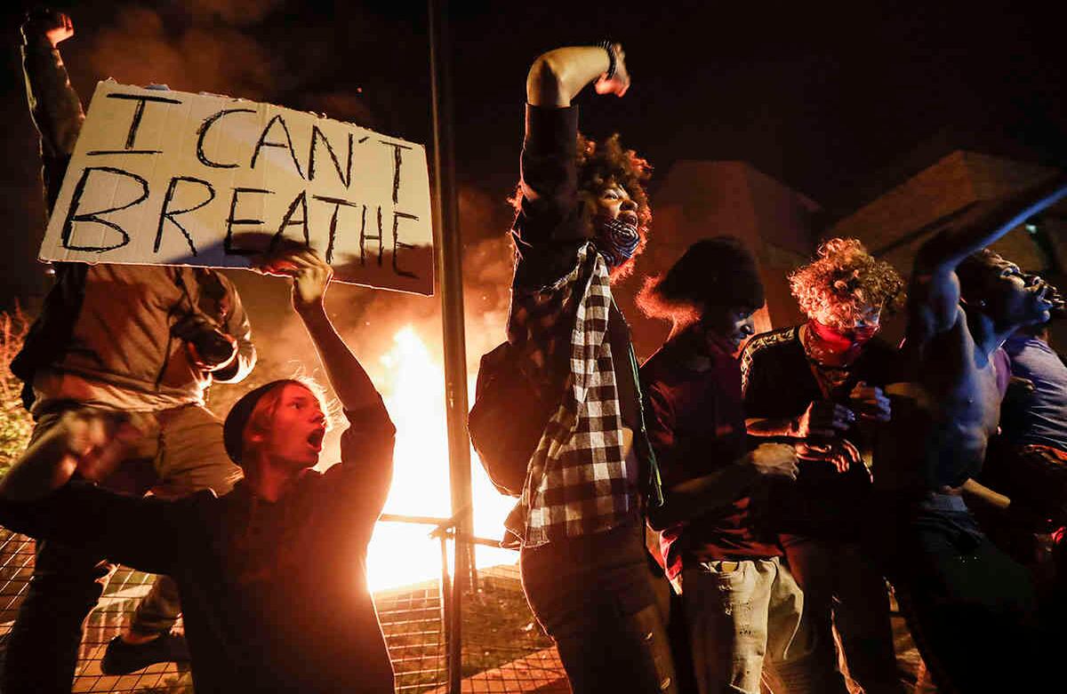 Los manifestantes protestan fuera de un tercer recinto policial de Minneapolis en llamas, el jueves 28 de mayo de 2020. (Foto AP / John Minchillo)