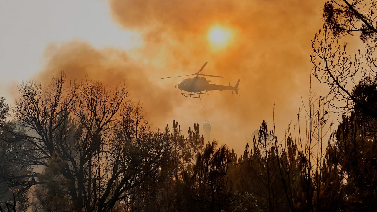 Helicóptero deja caer agua en un incendio forestal en Larouco, noroeste de España, miércoles 13 de agosto de 2025.