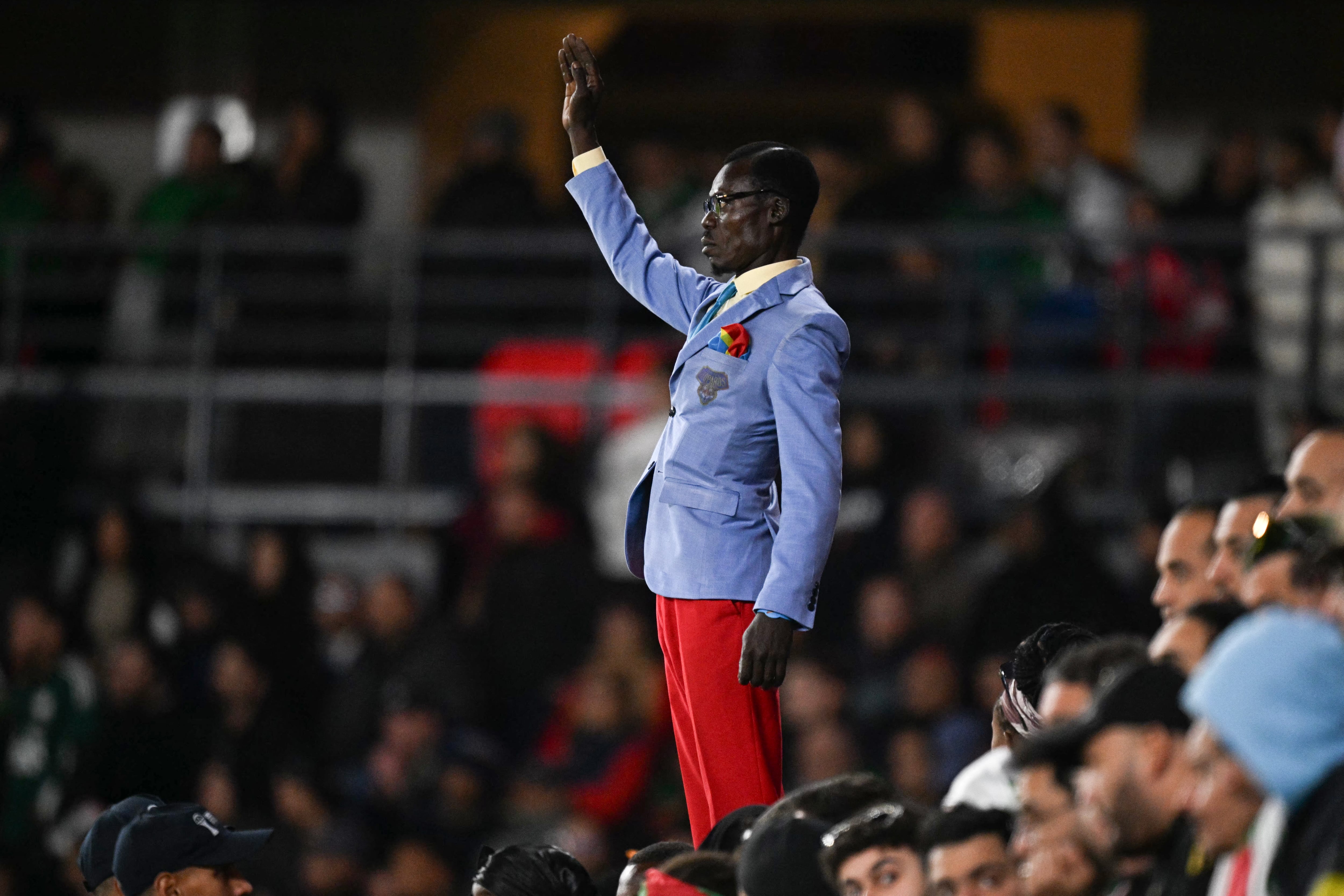 El hincha de la República Democrática del Congo, Michel Kuka Mboladinga, rinde homenaje al difunto primer ministro Patrice Lumumba, permaneciendo inmóvil antes del partido. Foto: Gabriel BOUYS / AFP