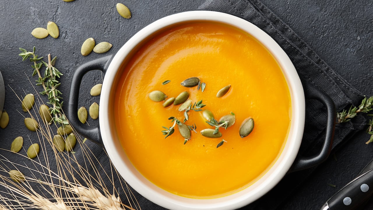 Sopa de calabaza con semillas de tomillo y calabaza sobre fondo negro. Auyama, ahuyama, alimentos, crema