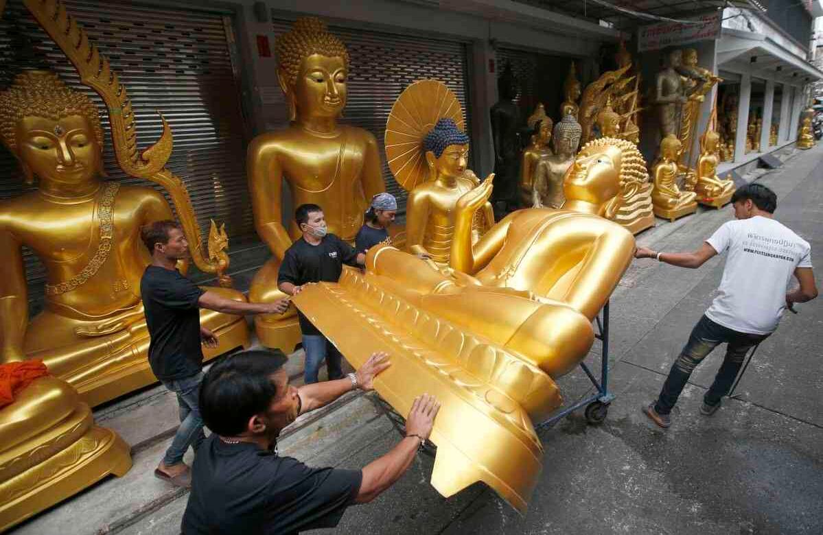Trabajadores tailandeses retiran una estatua de Buda en una tienda en Bangkok, Tailandia, el martes 4 de julio de 2017, en preparación para la próxima Cuaresma Budista. Los monjes budistas regresan a sus monasterios para estudiar las enseñanzas de Buda. (AP Photo / Sakchai Lalit)