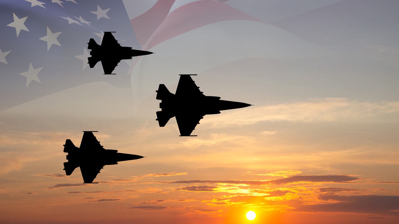 Aviones de combate con bandera de EE. UU. contra el cielo del atardecer.