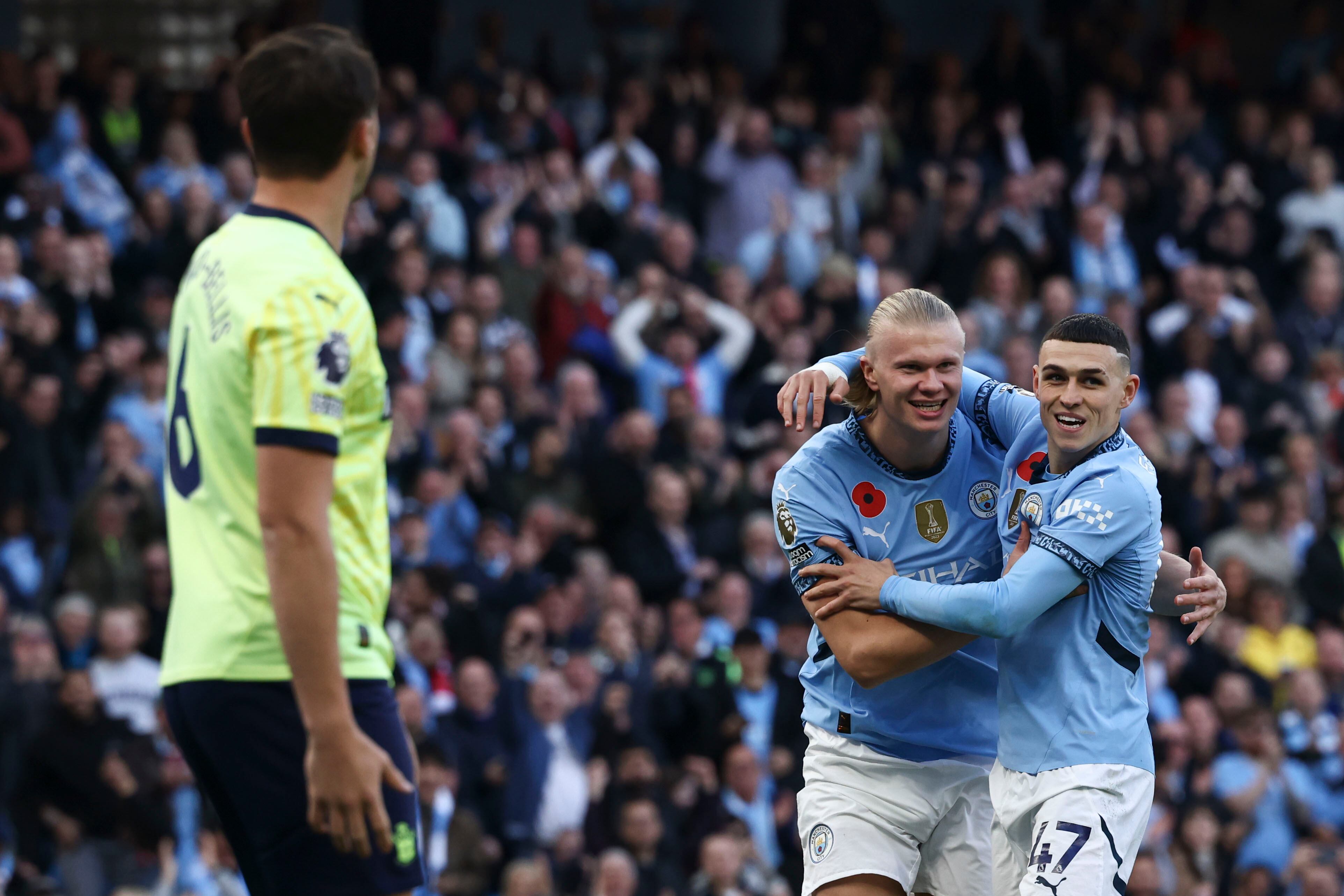 Manchester City's Erling Haaland, second right, celebrates with Manchester City's Phil Foden after scoring his side's opening goal during the English Premier League soccer match between Manchester City and Southampton at the Etihad Stadium in Manchester, England, Saturday, Oct. 26, 2024. (AP Photo/Darren Staples)