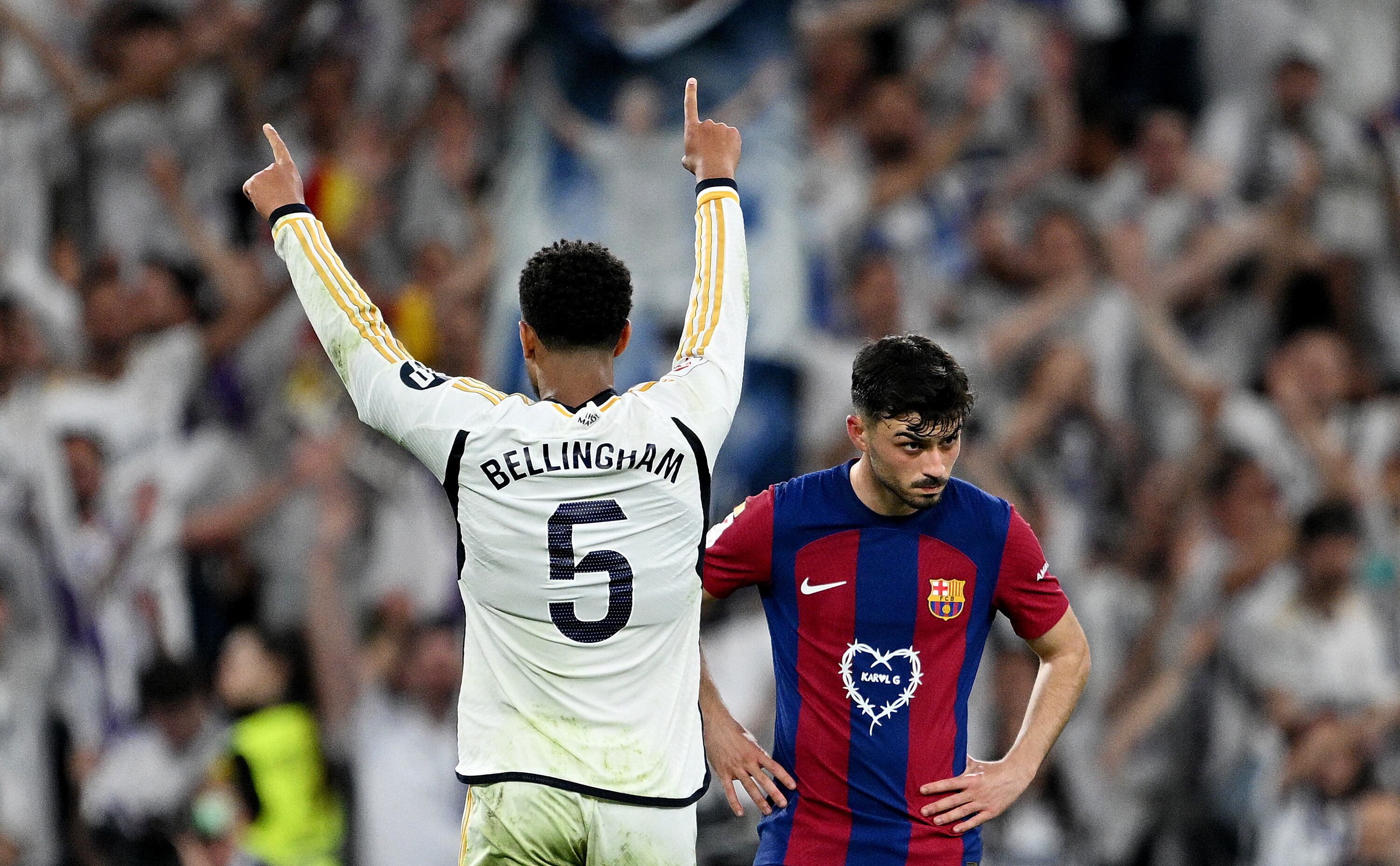 MADRID, SPAIN - APRIL 21: Pedri of FC Barcelona looks dejected as Jude Bellingham of Real Madrid celebrates scoring his team's third goal during the LaLiga EA Sports match between Real Madrid CF and FC Barcelona at Estadio Santiago Bernabeu on April 21, 2024 in Madrid, Spain. (Photo by David Ramos/Getty Images)