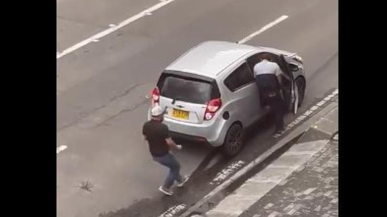 Los ladrones huyen en un carro, luego de asaltar a una persona que estaba en un trancón sobre la calle 100 con 19, en Bogotá.