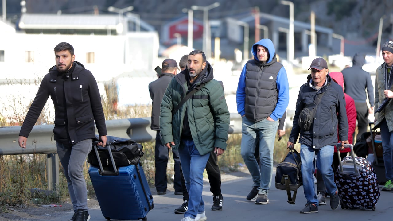Un grupo de ciudadanos rusos caminan con su equipaje tras cruzar la frontera en Verkhny Lars, entre Georgia y Rusia en Georgia, el 27 de septiembre de 2022. (AP Foto/Zurab Tsertsvadze)
