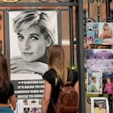 Dos mujeres miran los retratos de la princesa Diana y otros recuerdos expuestos en las puertas del Palacio de Kensington, en Londres, el martes 30 de agosto de 2022. Esta semana se cumple el 25 aniversario de la muerte de la princesa Diana en un accidente automovilístico en París. Foto AP/Alastair Grant