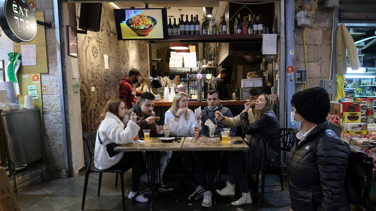 People eat at a restaurant in Jerusalem's main market after authorities reopened restaurants, bars and cafes to "green pass" holders (proof of having received a covid-19 vaccine), on March 11, 2021. (Photo by Emmanuel DUNAND / AFP)