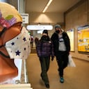 People walk past face masks displayed for sale in St. Petersburg, Russia, Monday, Jan. 24, 2022. Daily new coronavirus infections in Russia have reached an all-time high and authorities are blaming the highly contagious omicron variant, which they expect to soon dominate the country's outbreak. (AP Photo/Dmitri Lovetsky)