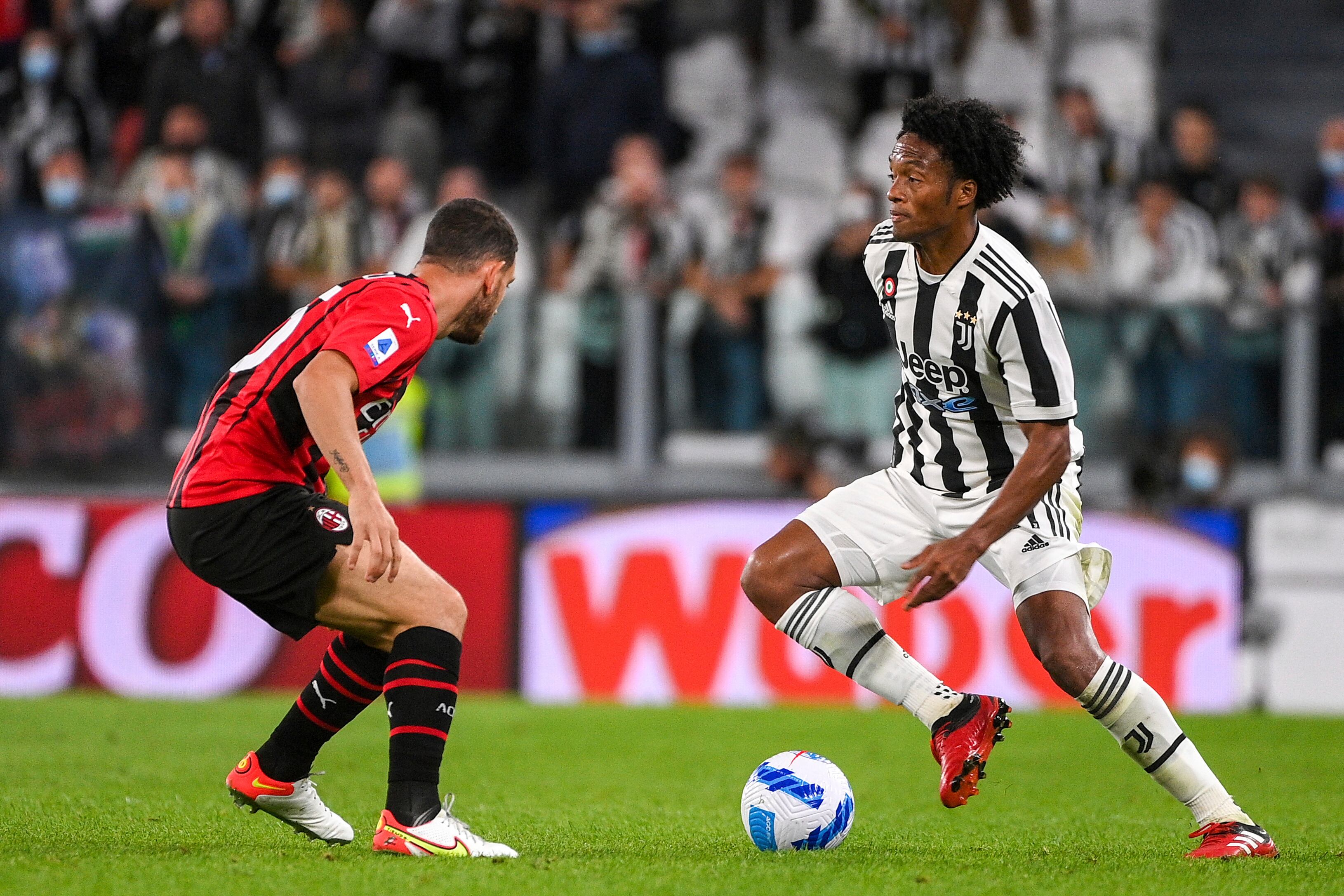 Juventus' Juan Cuadrado, right, takes on AC MIlan's Alessio Romagnoli during the Serie A soccer match between Juventus and AC Milan, at the Turin Allianz stadium, Italy, Sunday, Sept. 19, 2021. (Marco Alpozzi/LaPresse via AP)