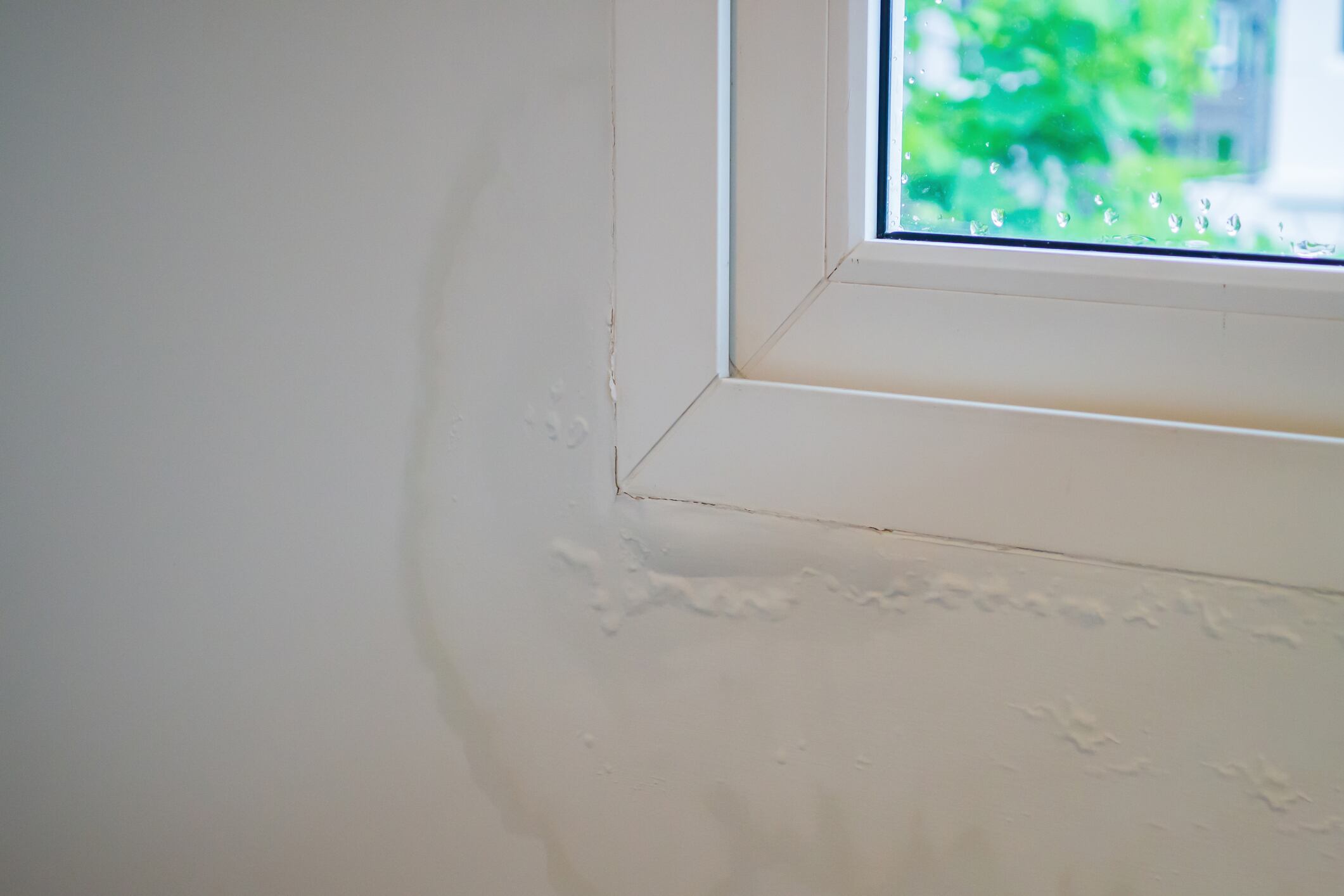 house wall near the window with some water stain show peeling paint