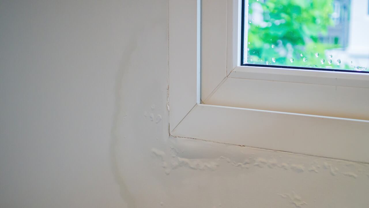 house wall near the window with some water stain show peeling paint