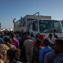 FILE - In this Tuesday, Nov. 24, 2020 file photo, Tigray refugees who fled the conflict in Ethiopia's Tigray region, wait to receive aid at Umm Rakouba refugee camp in Qadarif, eastern Sudan. A key U.N. aid agency says needs for humanitarian assistance have ballooned this year because of COVID-19, projecting that a staggering 235 million people — who together would make up the world's fifth most-populous country — are likely to require such help next year for troubles like the pandemic as well as war, forced migration and the impact of global warming (AP Photo/Nariman El-Mofty)