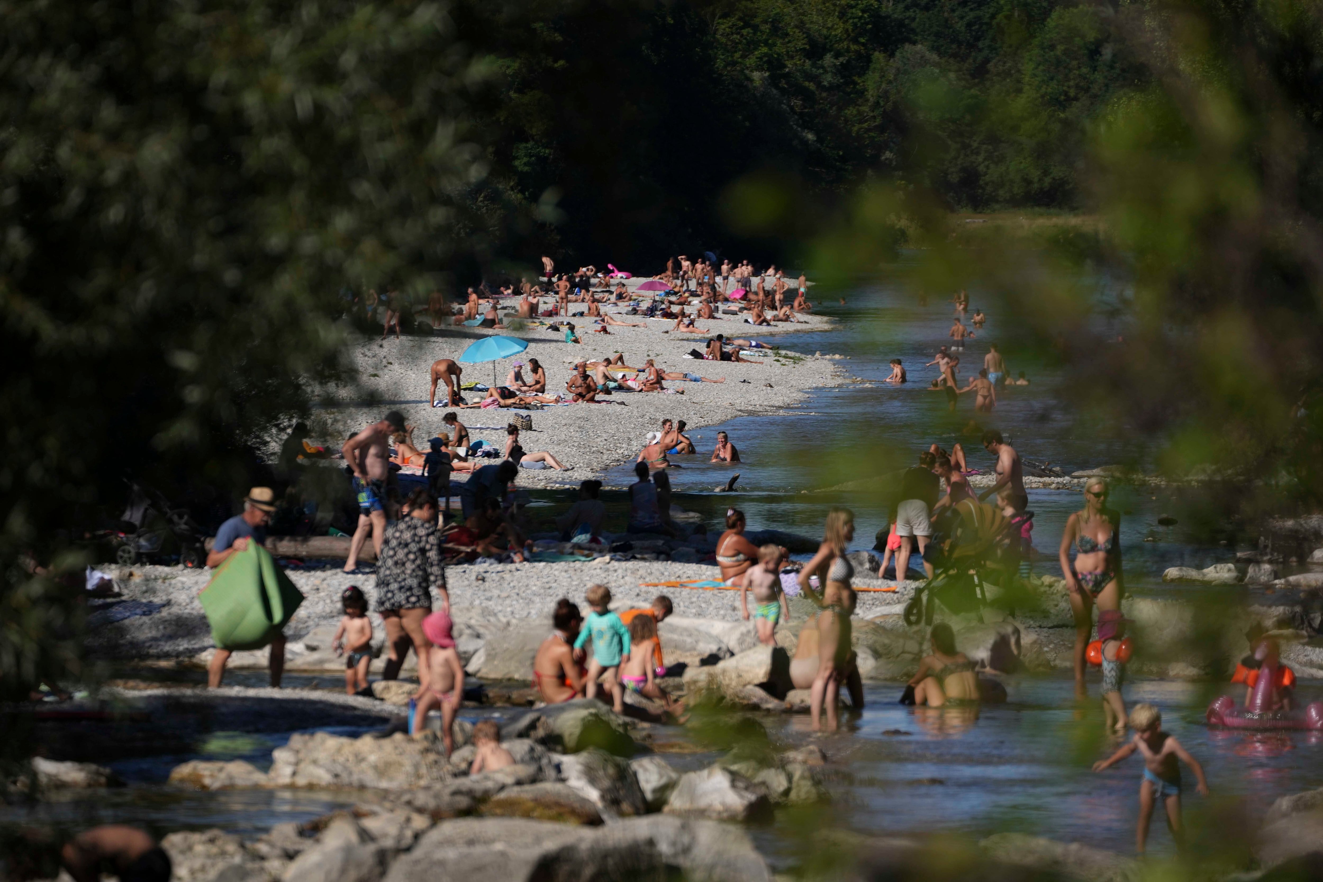La gente disfruta del clima caluroso de verano en las orillas del río 'Isar' en Munich, Alemania, el 3 de agosto de 2022.