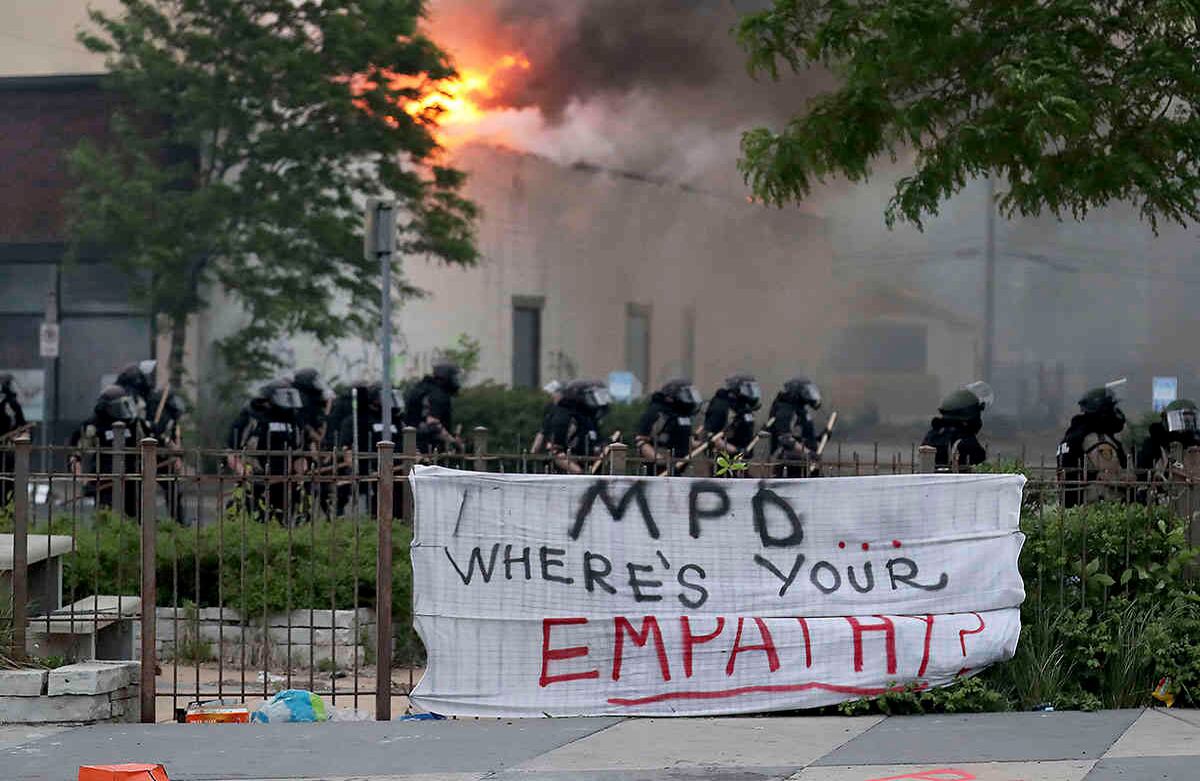  Los agentes de la ley protegen a los bomberos de Minneapolis a lo largo de Lake Street mientras los incendios ardían después de una noche de disturbios y protestas por la muerte de George Floyd (David Joles / Star Tribune a través de AP)