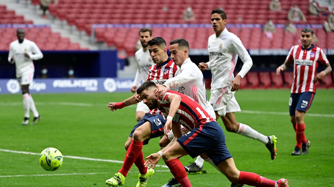 El centrocampista belga del Atlético de Madrid Yannick Ferreira-Carrasco (L) y el delantero uruguayo del Atlético de Madrid Luis Suárez (C) desafían al delantero español del Real Madrid Lucas Vázquez (R) durante el partido de fútbol de la liga española Club Atlético de Madrid contra el Real Madrid CF en el estadio Wanda Metropolitano en Madrid el 7 de marzo de 2021. (Foto de JAVIER SORIANO / AFP)