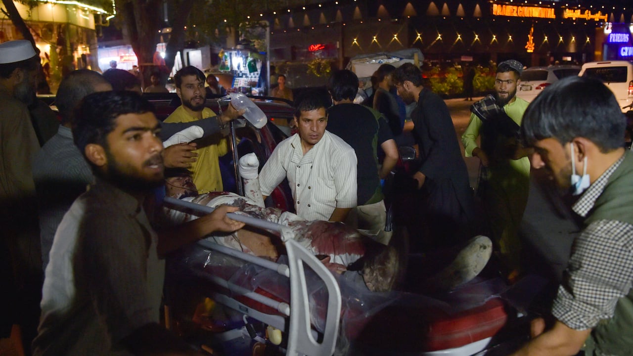 EDITORS NOTE: Graphic content / Volunteers and medical staff bring an injured man on a stretcher for treatment after two powerful explosions, which killed at least six people, outside the airport in Kabul on August 26, 2021. (Photo by Wakil KOHSAR / AFP)