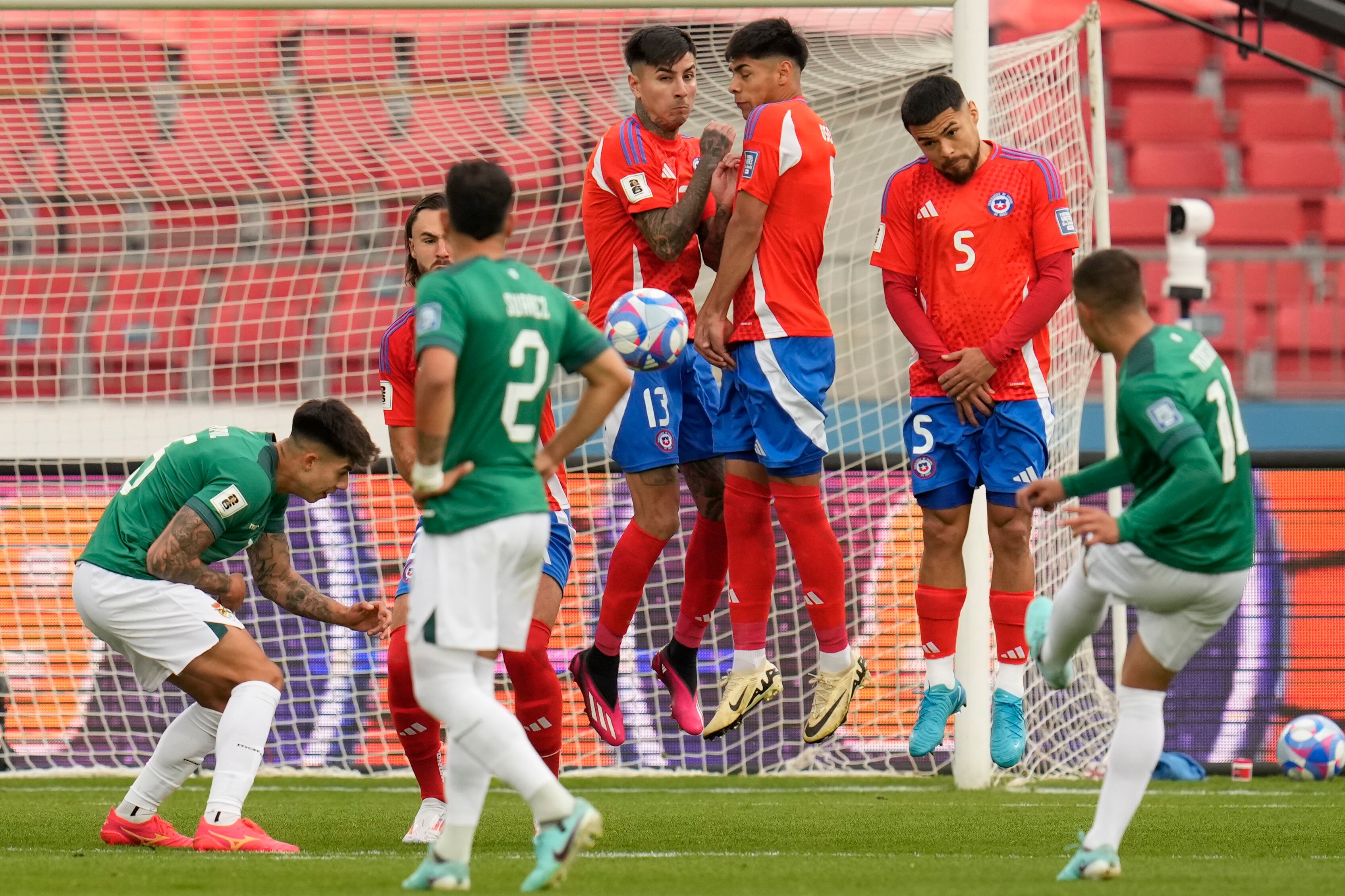 Los jugadores de Chile saltan para bloquear un tiro libre del boliviano Robson Matheus durante un partido de clasificación para la Copa Mundial de la FIFA 2026 en el Estadio Nacional en Santiago, Chile, el martes 10 de septiembre de 2024. (Foto AP/Esteban Felix)